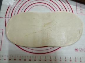 用擀面棍从中间往两边擀，不擀出头，擀成长方形