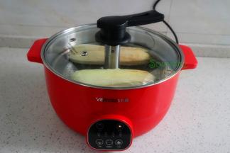 盖上盖子，大火蒸煮12分钟，蒸煮8分钟左右，翻转一次，让另外一面的玉米也能浸泡在水里蒸煮熟。