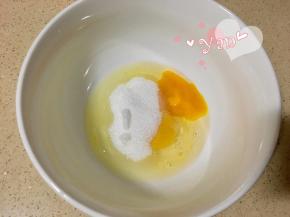 鸡蛋打入盆里，倒入细砂糖搅匀。