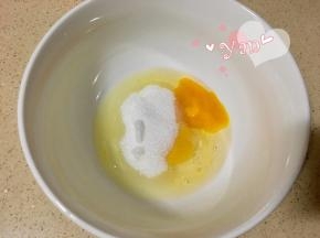 鸡蛋打入盆里，倒入细砂糖搅匀。
