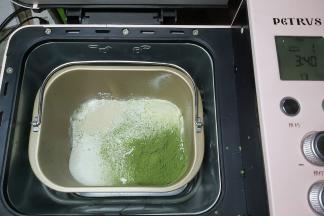 先把蛋液、牛奶、淡奶油、炼乳放入面包机桶内，接着把高筋面粉、奶粉、抹茶粉直接倒入桶内，细砂糖、耐高糖酵母对角放置，然后把面包桶装回面包机内。