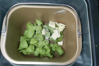 取出面团切成小块或者用剪刀剪成小块，同时把盐跟软化好的黄油一并放入面包桶内，然后再放回面包机，再次设置一个MIX程序。