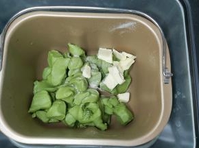 取出面团切成小块或者用剪刀剪成小块，同时把盐跟软化好的黄油一并放入面包桶内，然后再放回面包机，再次设置一个MIX程序。