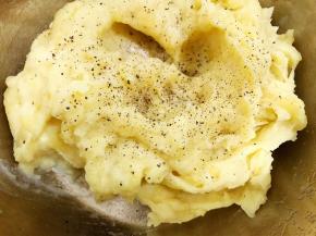 一边压一边看情况加入牛奶到如图状态，加入盐和黑胡椒碎搅拌均匀调味