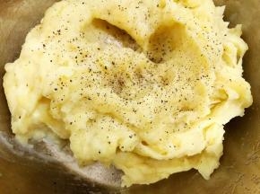 一边压一边看情况加入牛奶到如图状态，加入盐和黑胡椒碎搅拌均匀调味