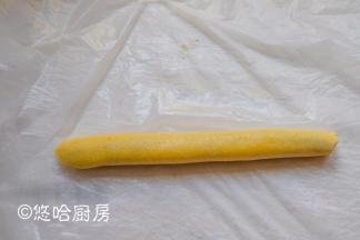 借助保鲜膜将面团包起红豆沙，卷紧。
