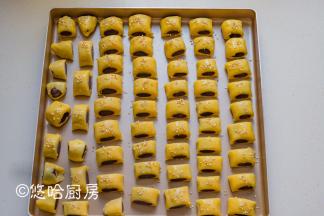 用刮板切成2公分左右的小段，摆放在烤盘中。这款面团烘烤后的膨胀力不大，所以不需要有很大间距。点心表面刷一点全蛋液（蛋黄液也OK），撒一点白芝麻。