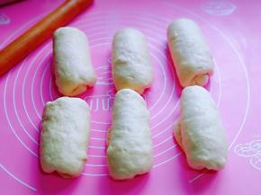 取一块面团，用擀面杖擀长舌状，由上往下卷起来，依次卷好，盖上保鲜膜醒10分钟。