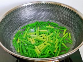 首先将蒜薹洗干净，再切段，之后焯水，锅中水烧开后下蒜薹段，大火1分钟捞出过冷水。