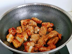 倒入排骨，翻炒挂色，使每块排骨均匀挂上糖色即可。