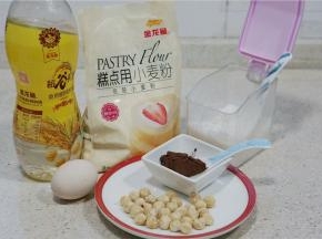 这款饼点的备料：金龙鱼谷物油80克，金龙鱼糕点用小麦粉150克，可可粉15克，白糖60克，鸡蛋1个，榛子1把