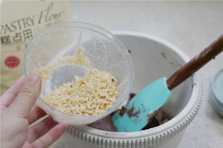 将榛子用料理器打细碎，再加至面糊里面。