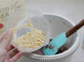 将榛子用料理器打细碎，再加至面糊里面。