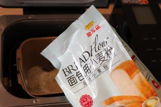 将水和橄榄油倒入面包机的面包桶中，盐、白砂糖对角放，倒入金龙鱼面包用小麦粉，这个粉采用100%进口小麦为原料，麦香浓郁，制作过程中易膨胀易拉丝，吸水性也好，面粉质量稳定性较好，成品香软可口；