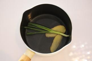 奶锅内放入姜片和葱条，倒入适量的水（配方外），烧开。