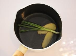 奶锅内放入姜片和葱条，倒入适量的水（配方外），烧开。
