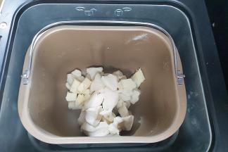 取出面团切成小块或者用剪刀剪成小块，同时把软化好的黄油一并放入面包桶内，然后再放回面包机，再次设置一个MIX程序。