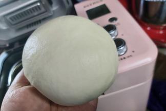 打好的面团表面光滑油亮，从面包机取出后简单收拢两下成团即可。