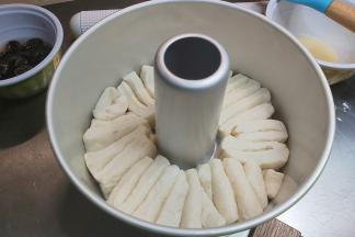 将8等份小面团竖起来垂直贴着烟囱排入模具内。