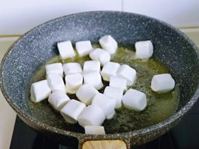 待黄油融化后，倒入棉花糖，保持小火，将棉花糖炒化开。