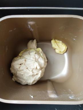 4、揉成团后放入软化的黄油继续揉 。