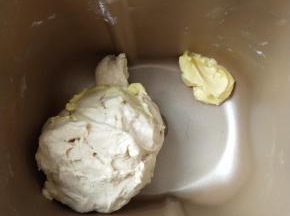 4、揉成团后放入软化的黄油继续揉 。