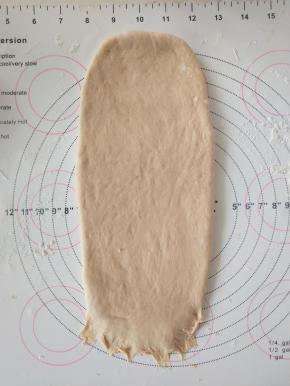 9、取面团擀成椭圆形，翻面，压薄底边。