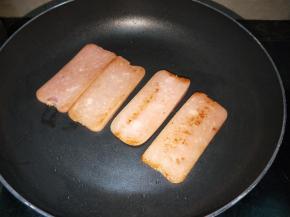 锅里放入少许的油，把火腿肉片煎一下