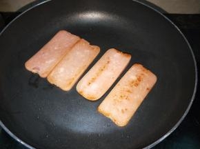 锅里放入少许的油，把火腿肉片煎一下