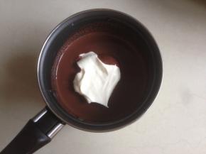 取少部分打发好的淡奶油，放入到已经冷藏过的巧克力液中拌均匀