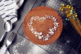 将冷藏好的蛋糕取出，用电吹风围着蛋糕模吹一圈，即可轻松脱模，在上面过筛一些可可粉，还可以在上面放一张图案板，过筛糖粉装饰一番