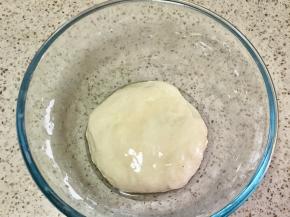 4.醒面后揉成光滑面团，在盆地倒入一大勺油，放入面团，再倒入一大勺油，把面团嵚在油里，盖保鲜膜醒面30分钟以上