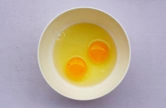鸡蛋磕入碗中。