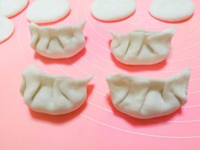 将馅料包入其中，捏成饺子状。