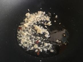 往炒锅中加入适量植物油，烧热后放入一半蒜蓉；