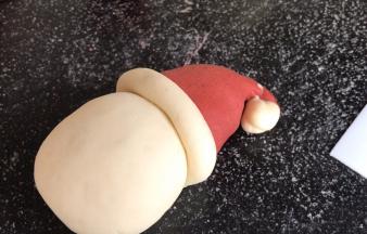 再取白面团搓成长条，放在红帽子底部