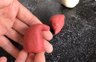 再取红面团，分成同白面团大小相同的团，搓成圣诞帽的形状