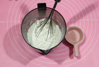 先将小苏打倒入低粉中，用手动打蛋器搅打均匀。这一步不可省略，这样再过筛，小苏打分布均匀，不会集中在一个角落。