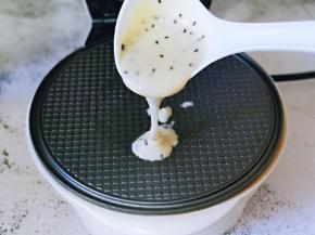 蛋卷机器提前预热，刷少许食用油，再盛大半勺蛋卷糊倒入烤盘中。