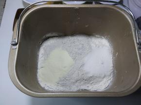 先把蛋液、牛奶、淡奶油放入面包机桶内，接着把高筋面粉、奶粉、黑米面粉直接倒入桶内，细砂糖、耐高糖酵母对角放置，然后把面包桶装回面包机内。