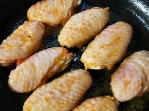 平底锅刷油，摆上鸡翅。