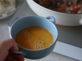 然后将食材划至一边，将鸡蛋加细盐打散下锅，炒至蛋液凝固。