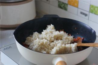 然后再加入冷饭，加冷饭的时候就可以加入细盐，如果是偏粗粒一点的盐，更是要早点放，然后分次加，这样子咸味才会分布的更加均匀。