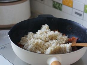 然后再加入冷饭，加冷饭的时候就可以加入细盐，如果是偏粗粒一点的盐，更是要早点放，然后分次加，这样子咸味才会分布的更加均匀。