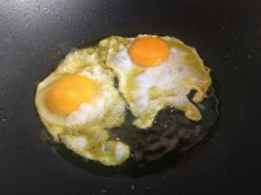 起锅倒入稍多的食用油，油热磕入鸡蛋；