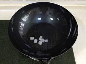 往新思特精铁锅中倒入适量的食用油，加入冰糖，中小火炒出糖色。