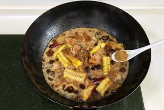 放入玉米和泡发好的香菇，倒入淹没食材的清水，加1小匙十三香。