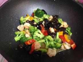 倒入西兰花、木耳、碗汁、红、黄椒快速炒匀即可上桌