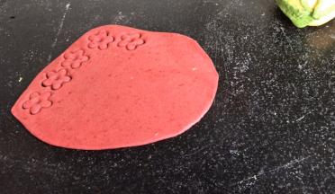 把红面团也擀成面皮，用压花模具压出小花