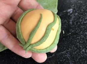 沾湿后，把叶子状贴在黄面球的两边，把花茎贴在中间